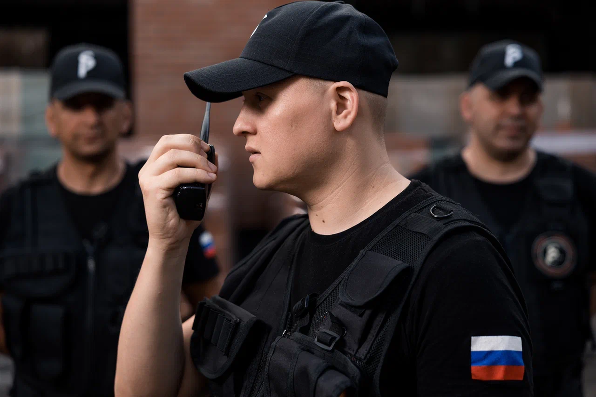 Сотрудник охраны координирует действия группы по рации