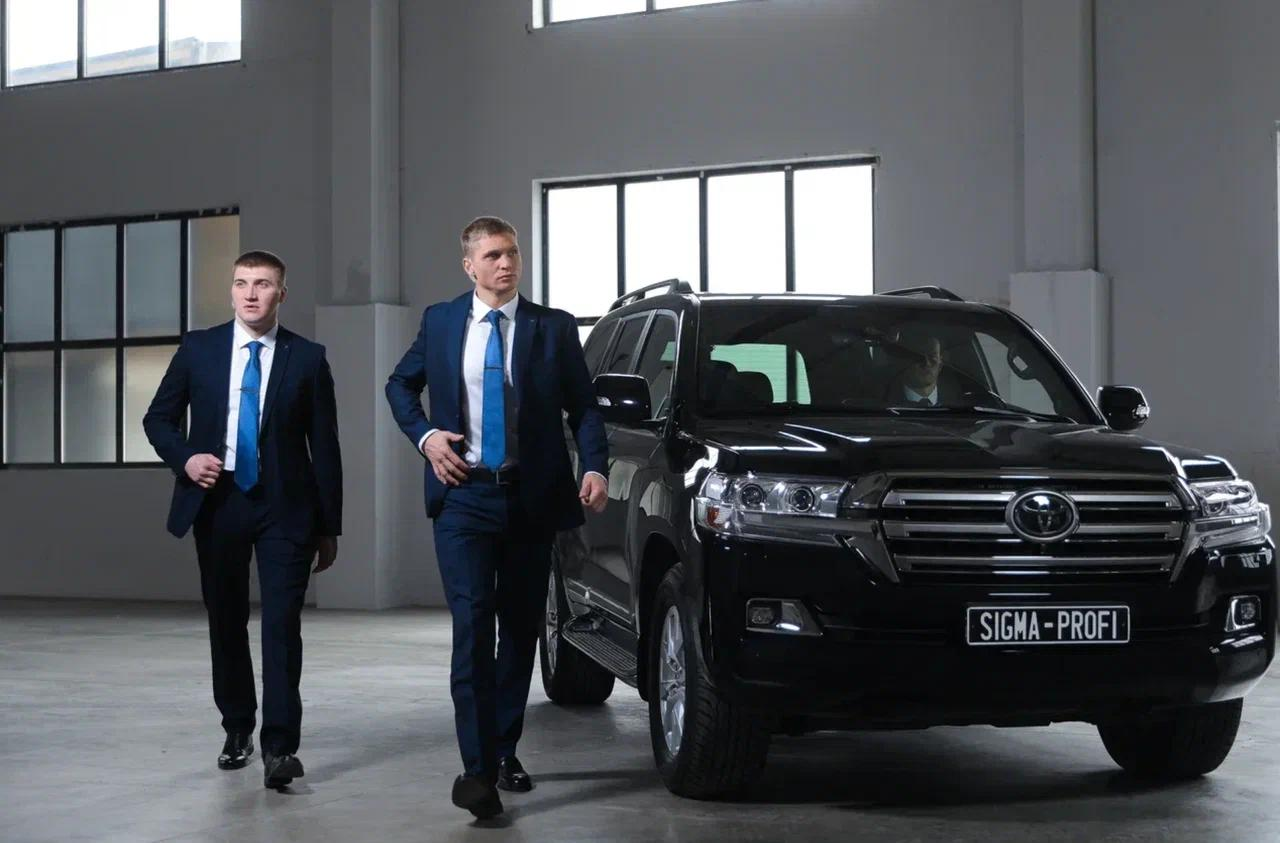Сотрудники ГК «Сигма-Профи» рядом с автомобилем сопровождения